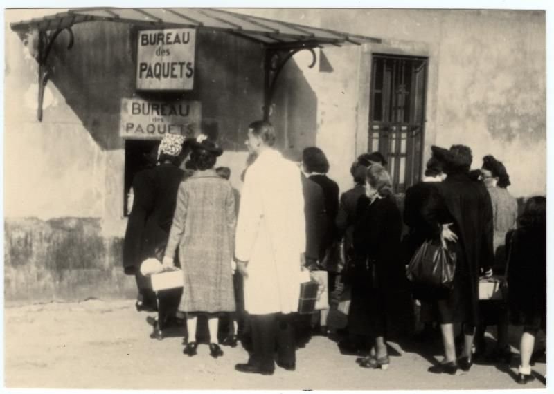 Families of internees from the Swiss barracks camp carrying parcels. Photo library of the International Committee of the Red Cross, rights reserved.